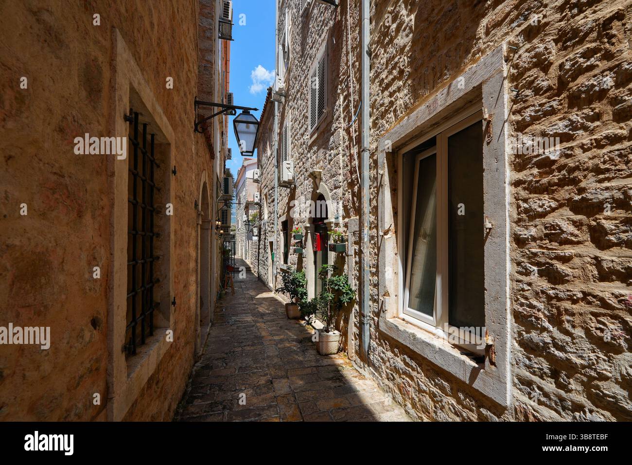 Stretta strada lastricata nella città vecchia di Budva, una città costiera fortificata costruita dalla Repubblica di Venezia lungo la costa del mare Adriatico in Montenegro Foto Stock