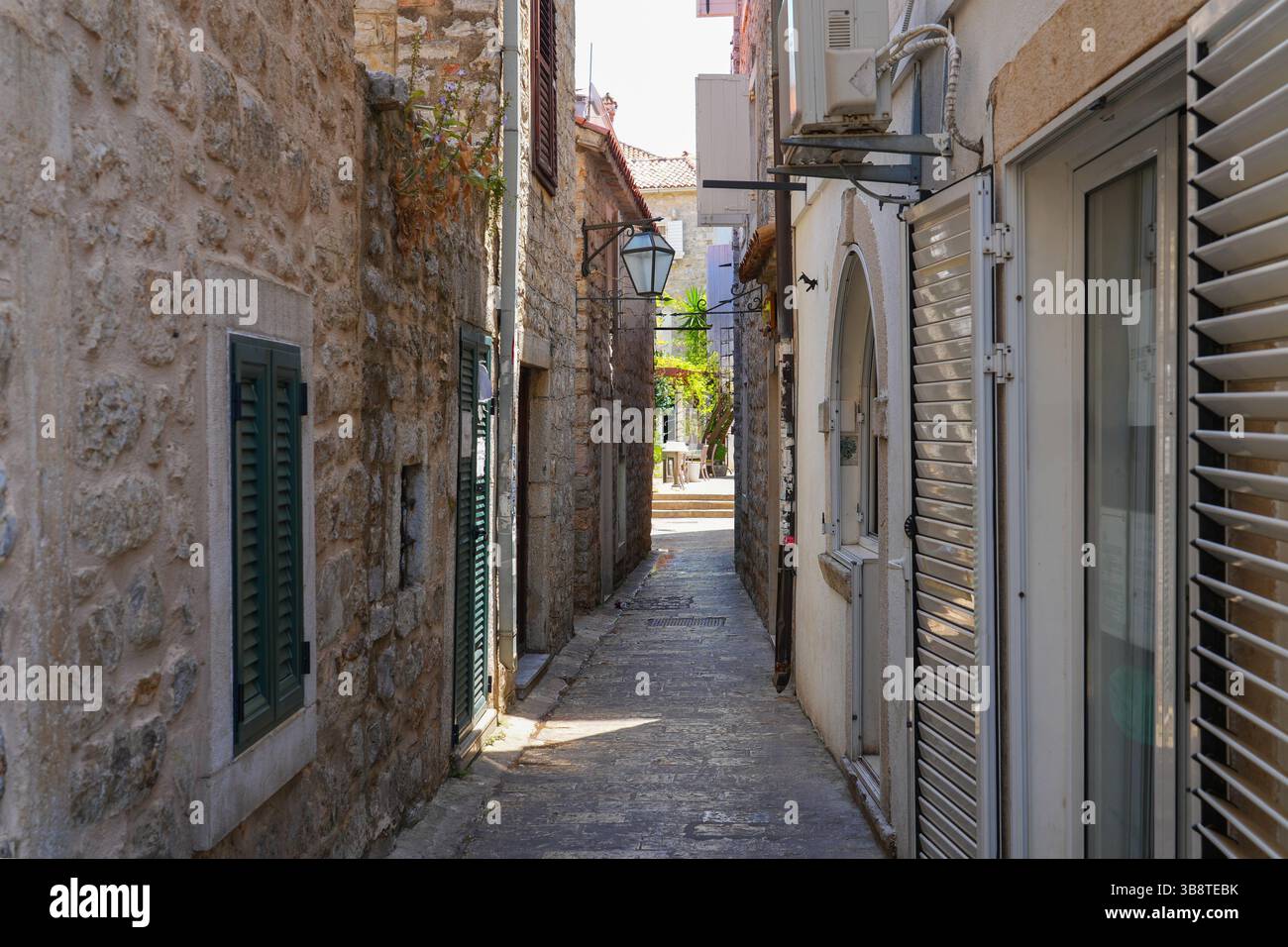Stretta strada lastricata nella città vecchia di Budva, una città costiera fortificata costruita dalla Repubblica di Venezia lungo la costa del mare Adriatico in Montenegro Foto Stock