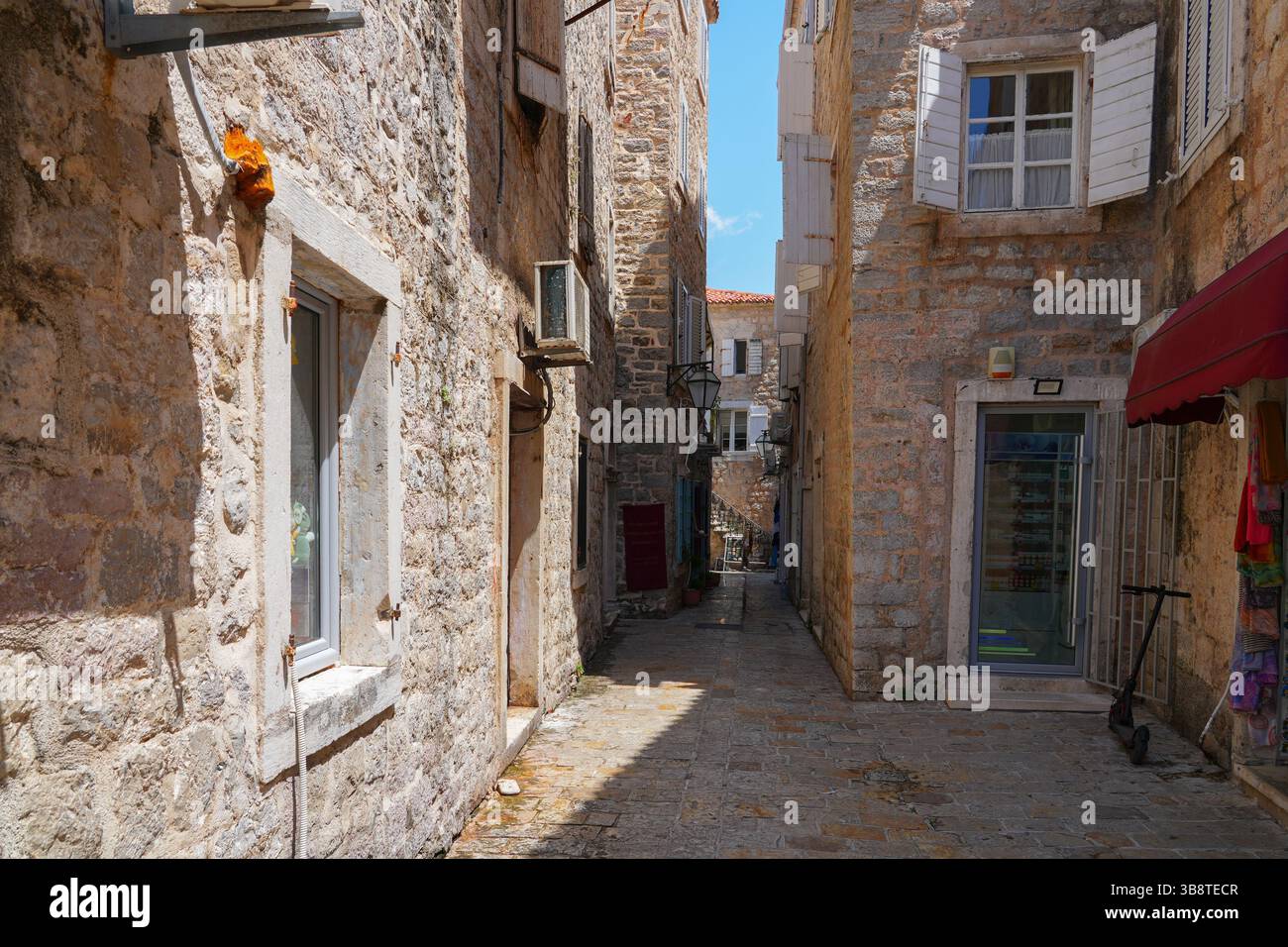 Stretta strada lastricata nella città vecchia di Budva, una città costiera fortificata costruita dalla Repubblica di Venezia lungo la costa del mare Adriatico in Montenegro Foto Stock