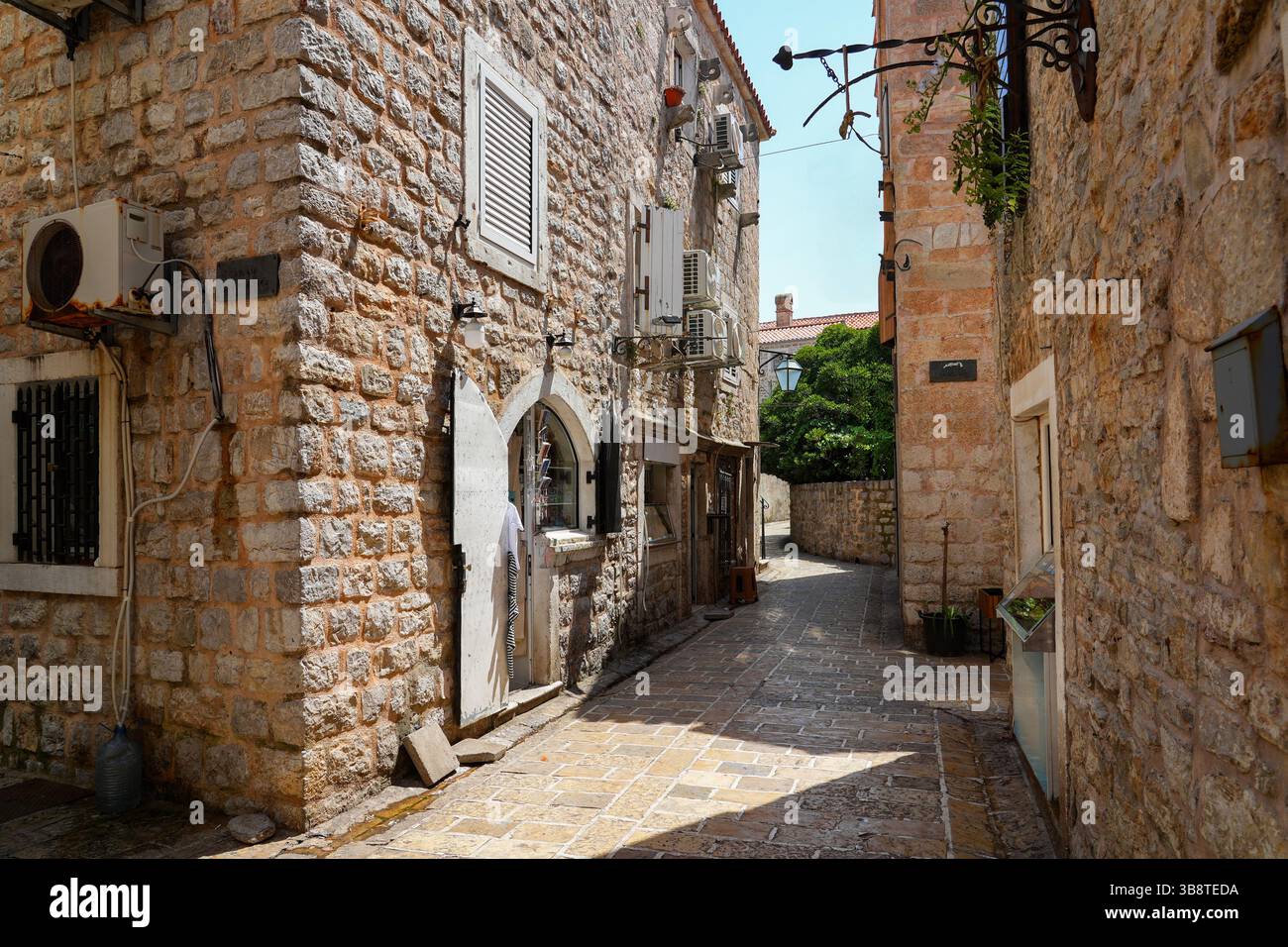 Stretta strada lastricata nella città vecchia di Budva, una città costiera fortificata costruita dalla Repubblica di Venezia lungo la costa del mare Adriatico in Montenegro Foto Stock