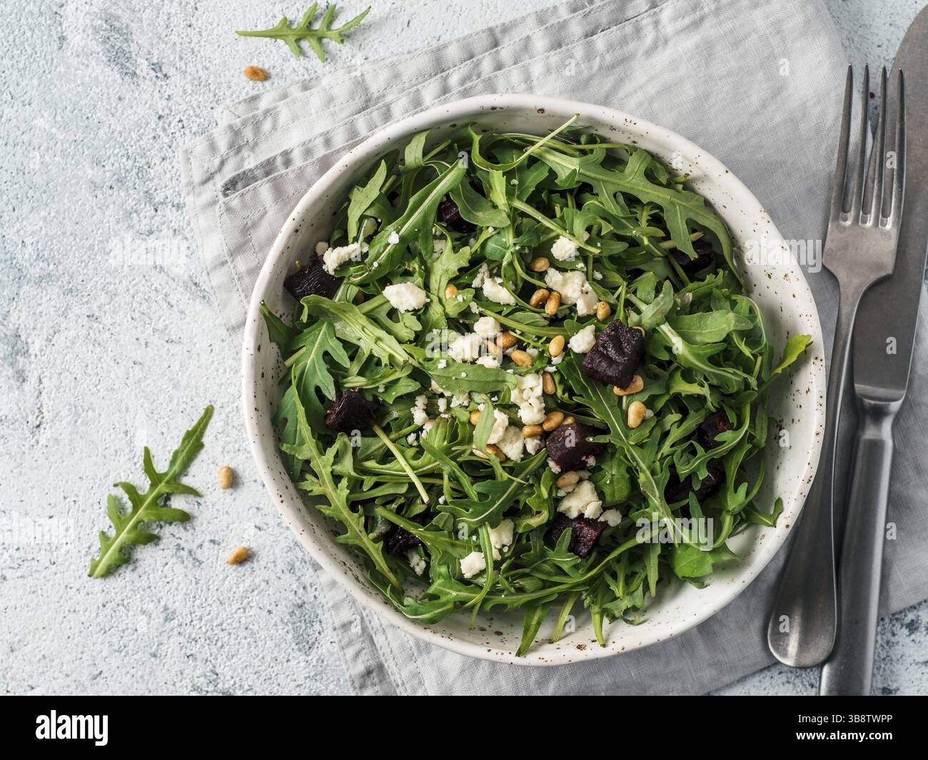 Barbabietola, aragola e insalata di formaggio morbido su sfondo grigio. Vista dall'alto o in piano. Spazio di copia per il testo. Idea e ricetta per una sana estate vegetariana Foto Stock