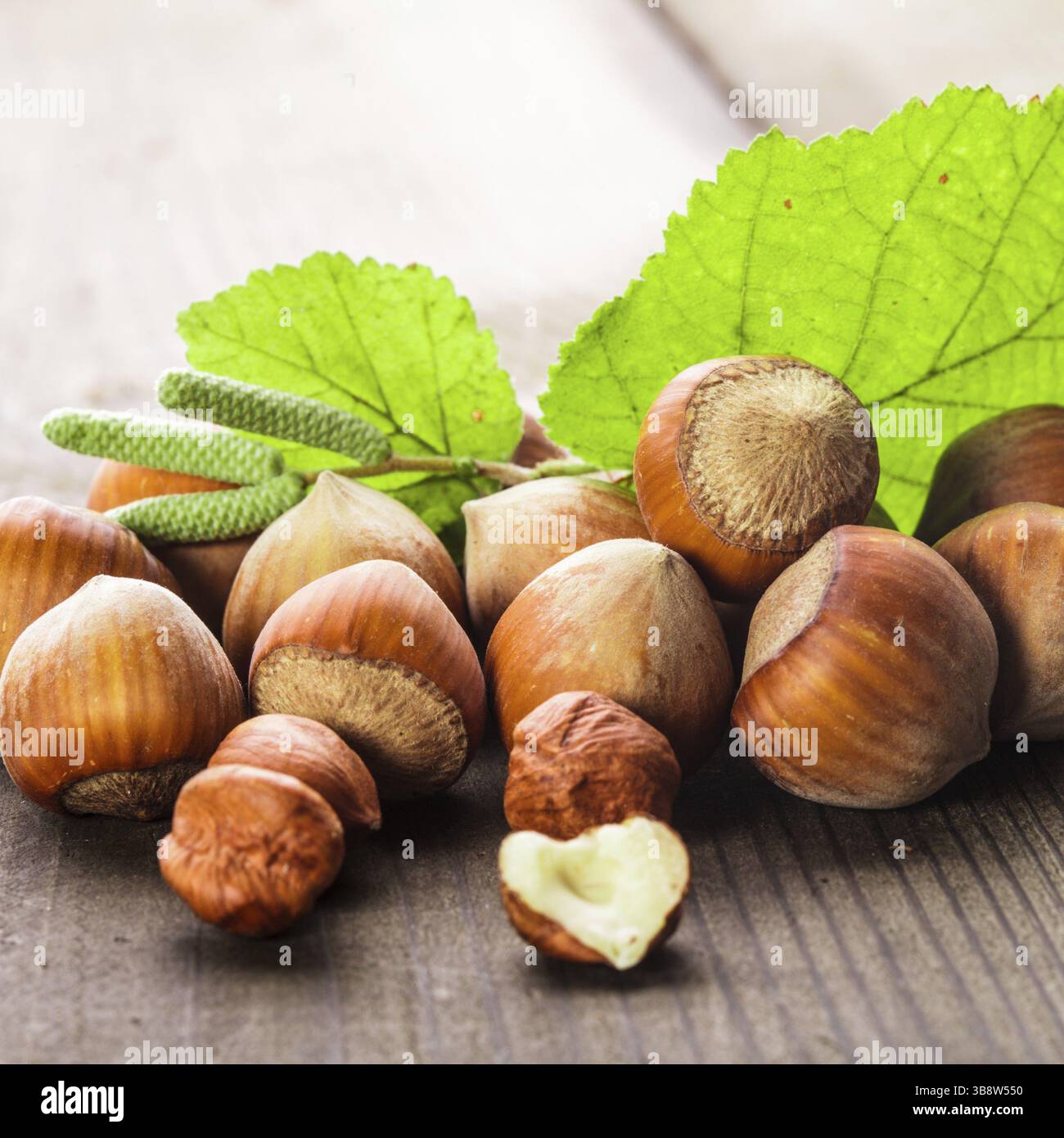 Le nocciole con guscio e foglia verde sul tavolo di legno Foto Stock