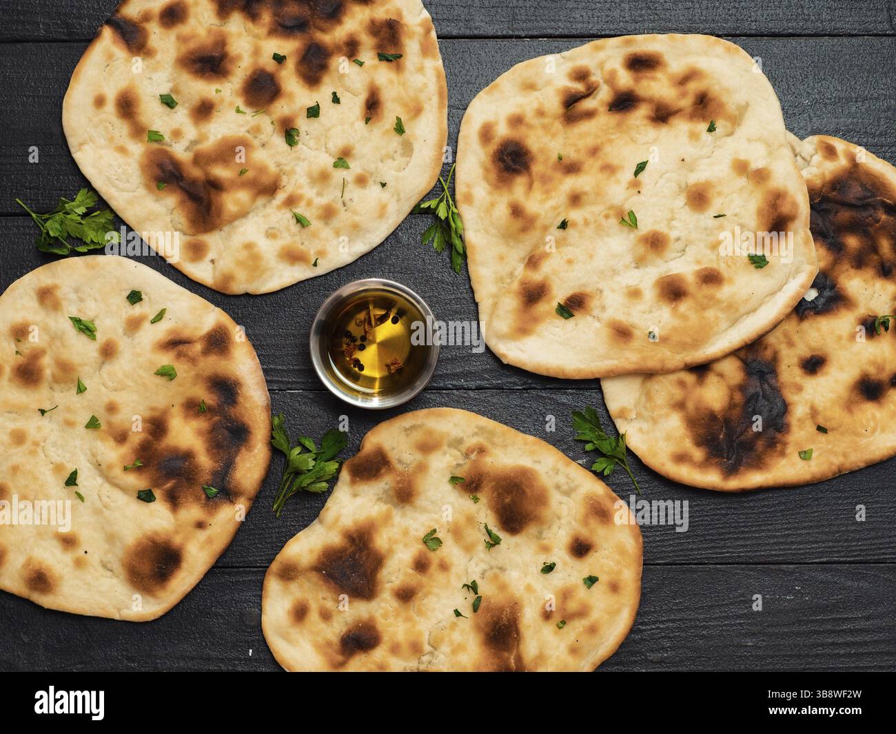 Pane naan fresco su sfondo di legno scuro con spazio per le copie. Diversi piatti naan con vista dall'alto o piatti Foto Stock