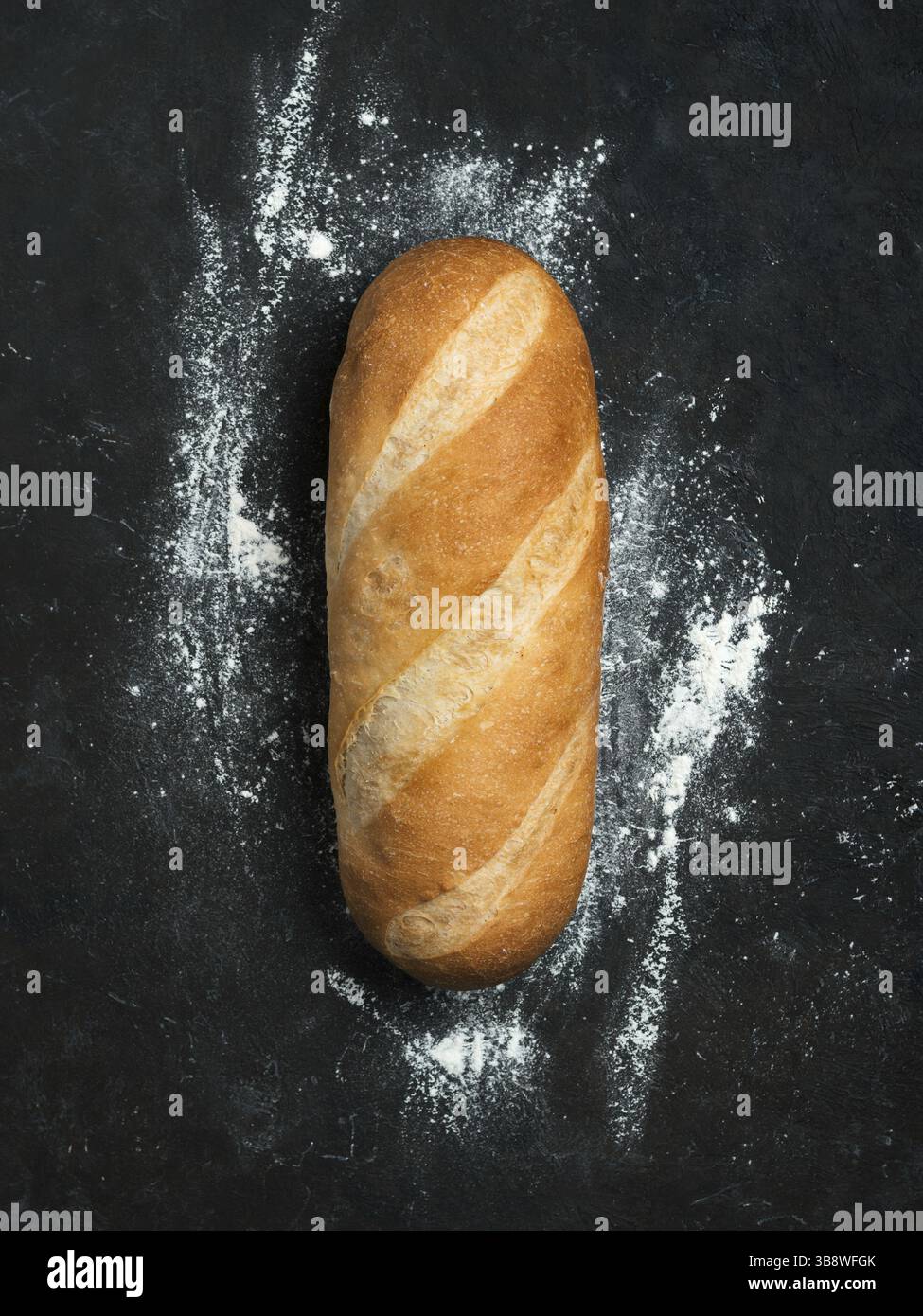 White Bloomer britannico o pane europeo con pane a forma di Baton su sfondo nero. Vista dall'alto o disposizione piatta. Spazio di copia per testo o progetto. Verticale Foto Stock