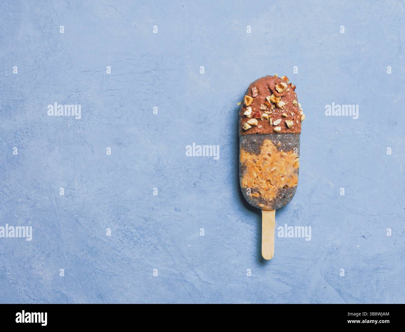 Papavero Chia con torta di carote cruda e cioccolato su sfondo blu. Ricetta sana e idea gelato vegan fatto in casa a base di papaveri. L'idea del dessert pasquale. C Foto Stock