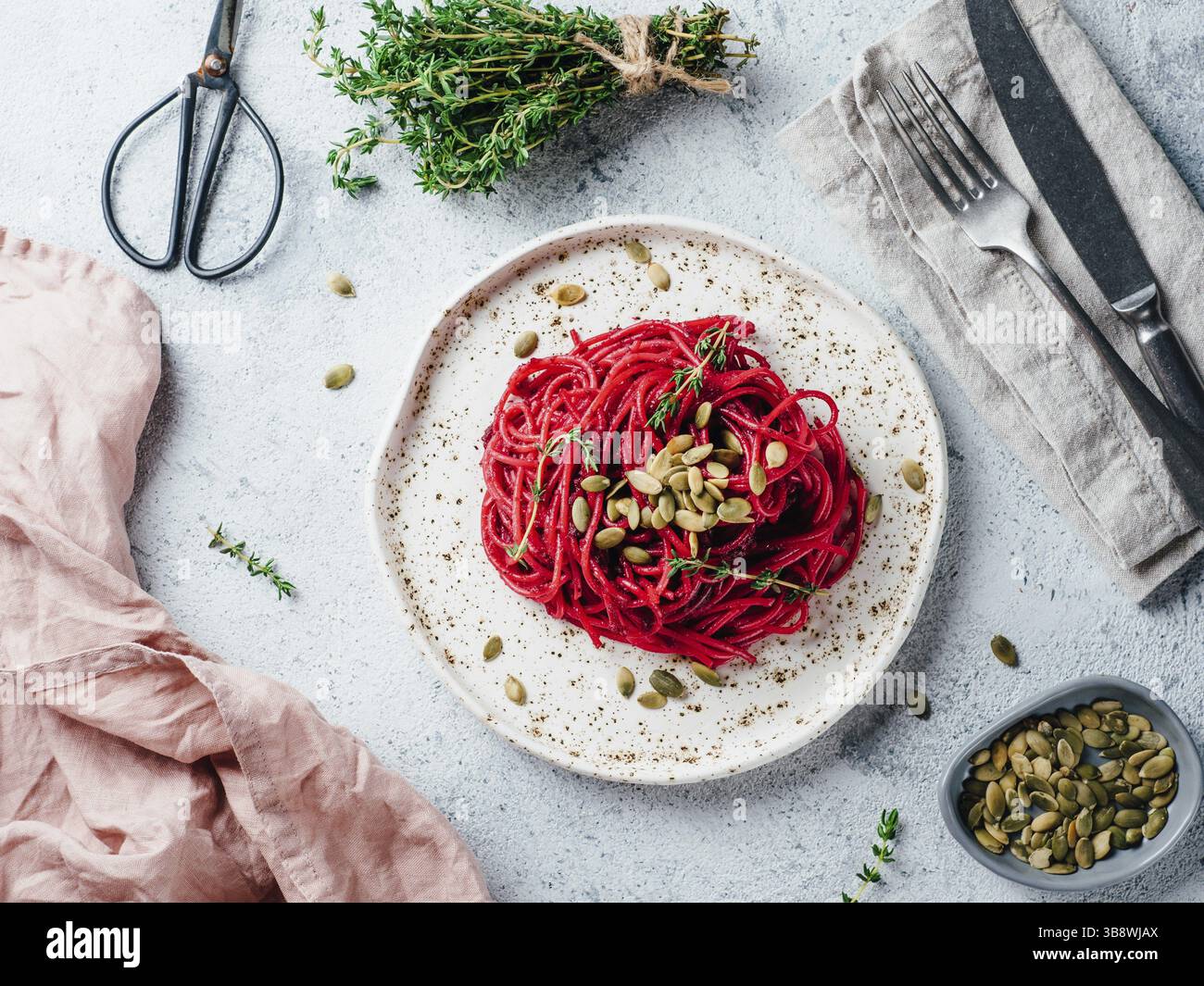 Pesto di barbabietole o hummus. Barbabietola in casa il pesto in barattolo di vetro e timo fresco scuro su sfondo nero. Copia spazio per il testo. Idee e ricette per Foto Stock