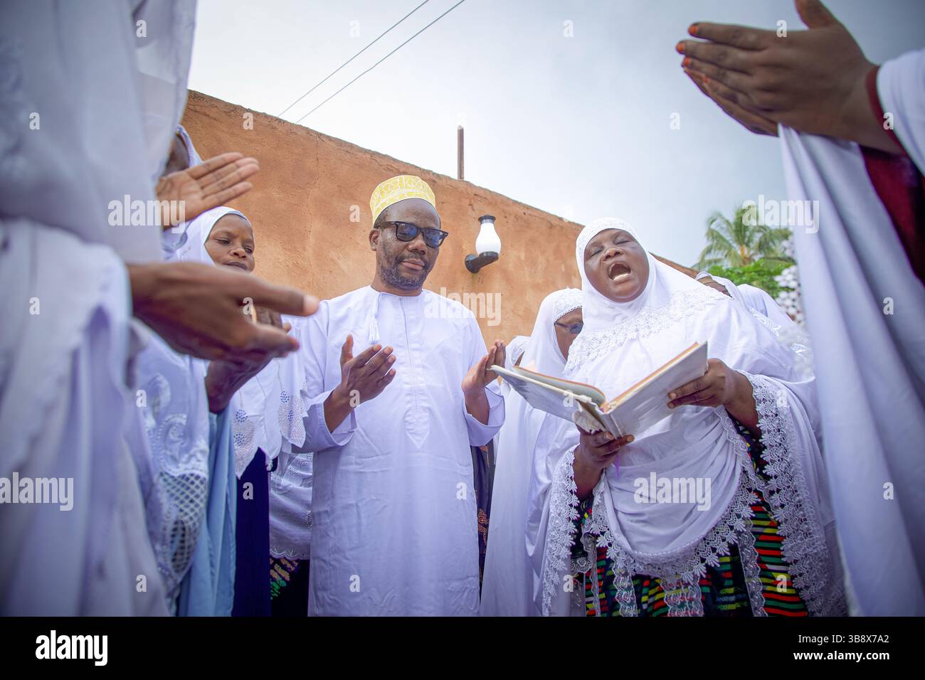 Donne musulmane che hanno completato l'Hajj pregando per l'ex leader del partito Wazalendo Zitto Kabwe nella sua casa nella città di Kigoma, Tanzania Foto Stock