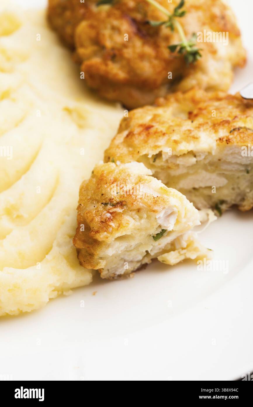 Cotolette di pollo e purè di patate in una piastra da vicino Foto Stock