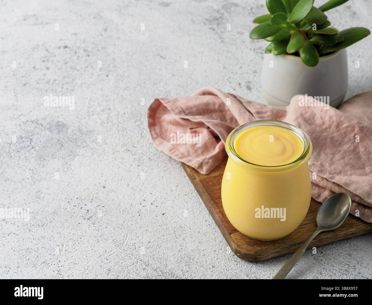 Lassi di mango giallo su sfondo grigio. Bevanda indiana allo yogurt mango con spazio per le copie a sinistra Foto Stock