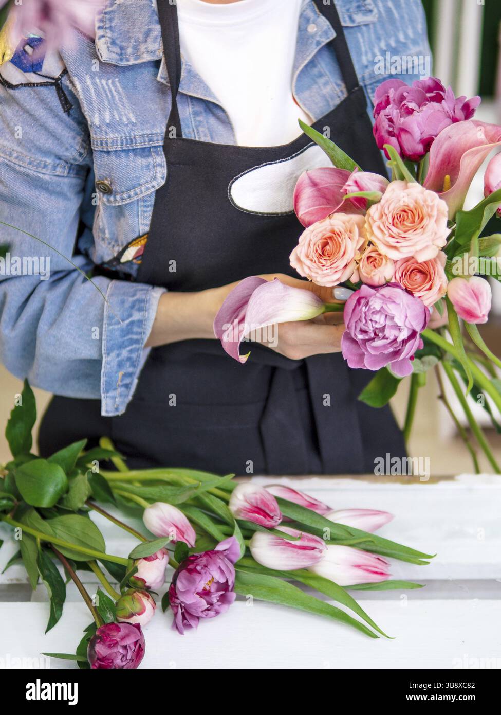 Fioraio mani raccogliere bouquet di fiori in studio. Fioraio creazione ordine, rendendo rosa peonia e tulip bouquet nel negozio di fiori. Fioraio sta facendo bou Foto Stock