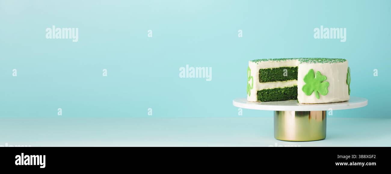 Il giorno di San Patrizio, il concetto di cibo dolce. Torta di velluto verde decorato foglie di shamrock verde per la festa di San Patrizio su sfondo blu. Spazio di copia. Lo Foto Stock