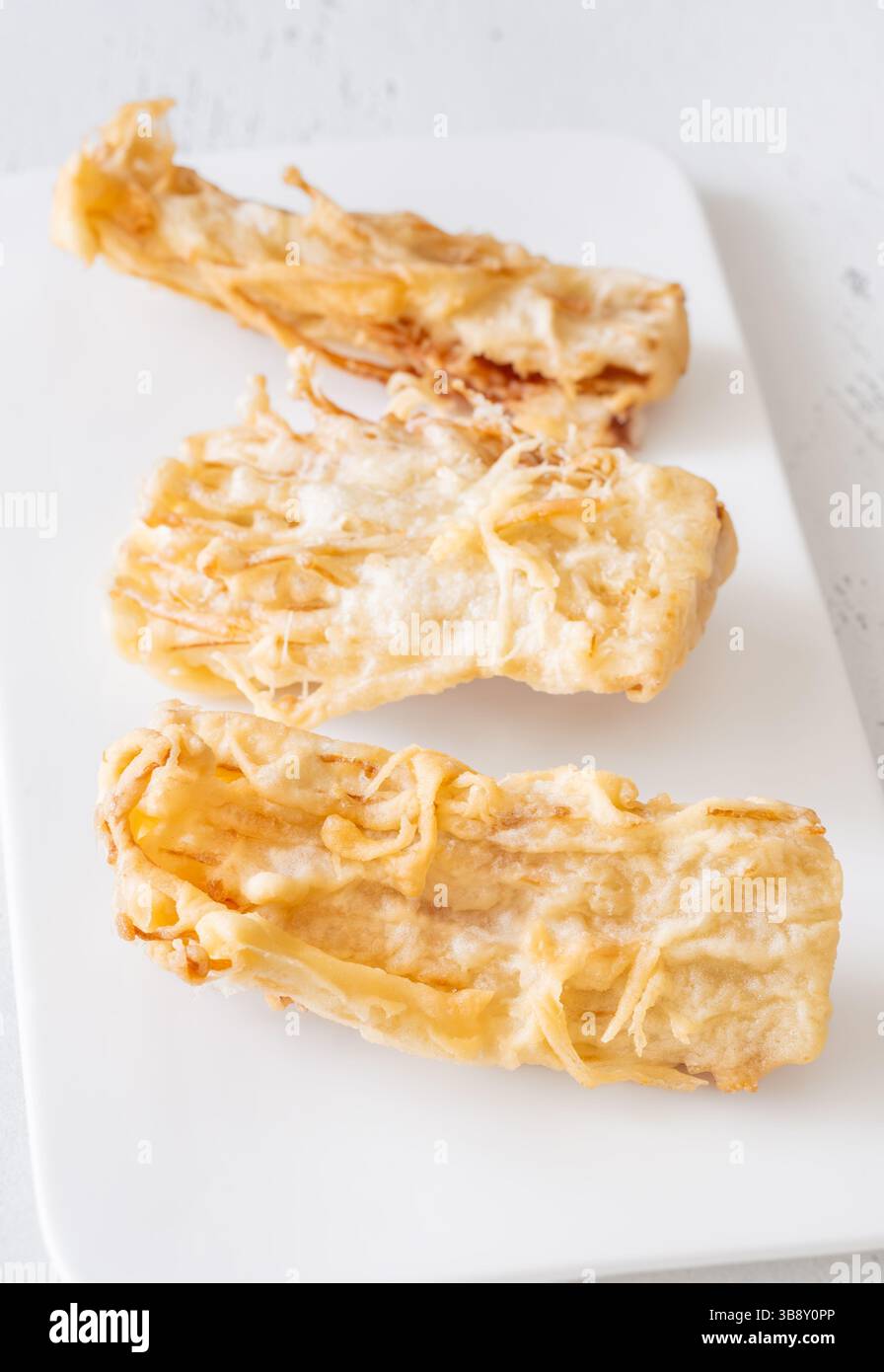 I grappoli di enoki dorati fritti in profondità per crogiolarsi alla perfezione Foto Stock