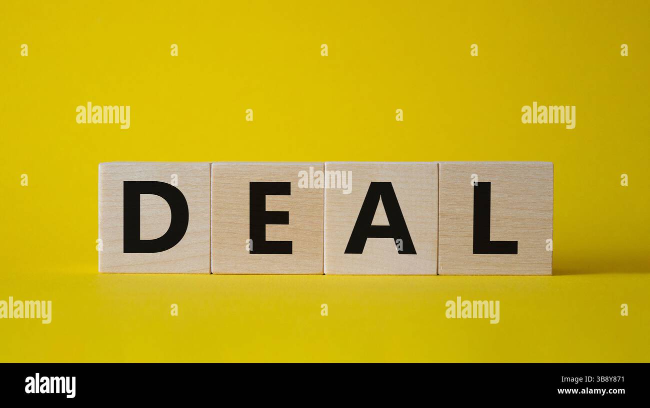 Simbolo dell'accordo. Concept Word deal su cubi di legno. Bellissimo sfondo giallo. Concetto di affari e affari. Copia spazio. Foto Stock