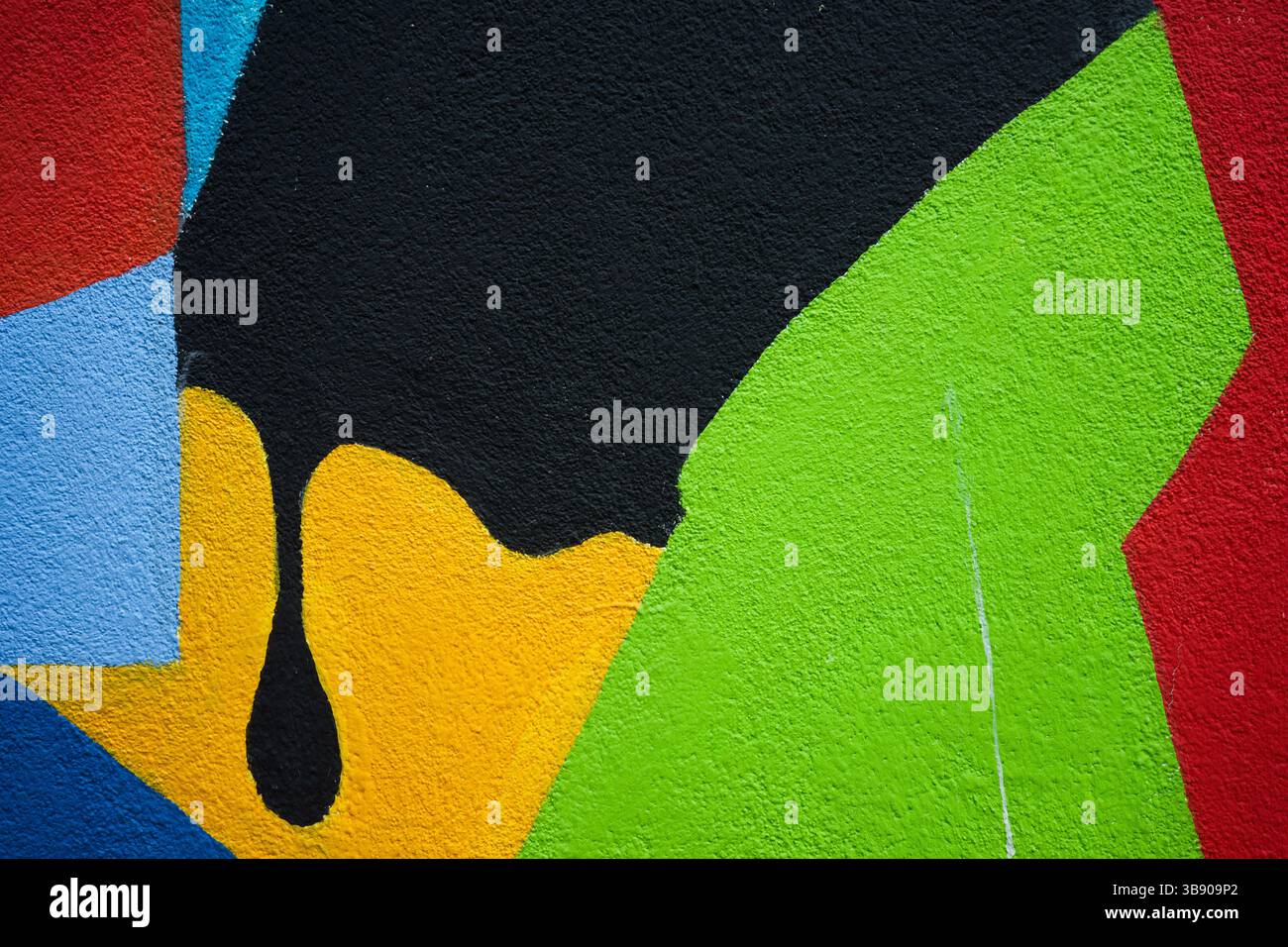 La consistenza di un muro dipinto con varie figure colorate. Foto Stock