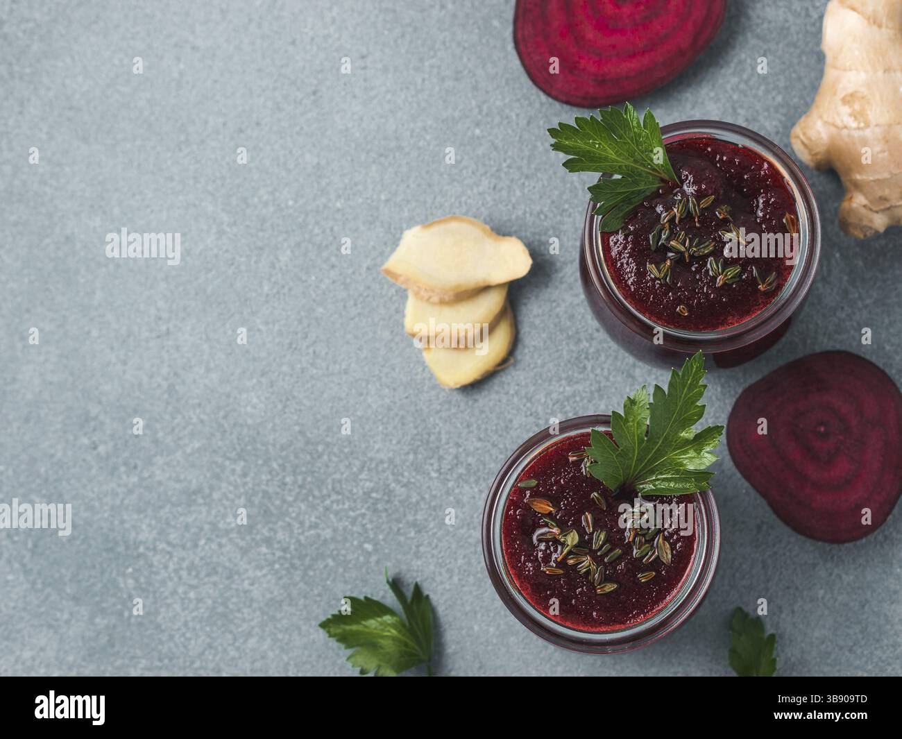 La barbabietola rossa fresca e radice di zenzero frullato. Frullato di barbabietole in un barattolo di vetro sulla tabella grigia. DOF poco profondo. Copia spazio per il testo. Pulire e mangiare concep detox Foto Stock