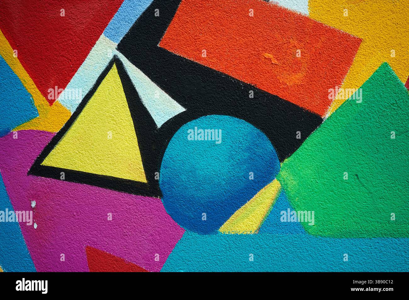 La consistenza di un muro dipinto con varie figure colorate. Foto Stock