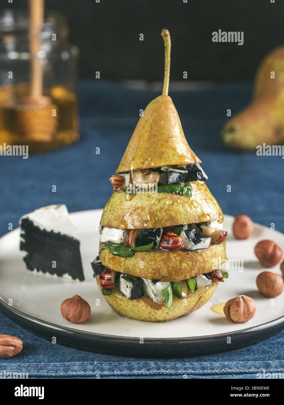 Pronto a mangiare insalata di divertimento con pera, nero formaggio, dadi, le foglie di basilico, miele. Idee e ricette per una sana prima colazione, cena appetiezer, insalata. È possibile utilizzare Foto Stock