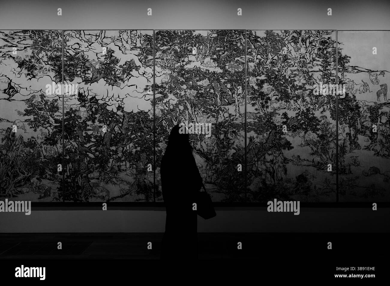 Sagomato contro il Black and White Mustard Seed Garden (racconto della serie dell'11° giorno), un visitatore contempla l'intricato pezzo Foto Stock