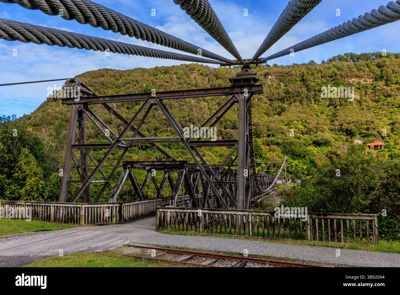 primo piano dei cavi di sospensione che conducono alla torre del ponte sospeso della miniera di brunner con il ponte che attraversa il fiume grigio sullo sfondo Foto Stock