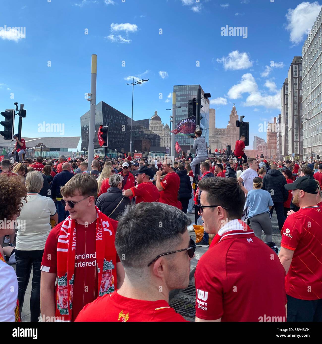 I tifosi si radunano nei pressi dei moli di Liverpool in vista della sfilata di vittorie della LFC il 29 maggio 2022, fiancheggiando le strade ore prima dell'arrivo del bus della squadra. - Immagine stock catturata con smartphone