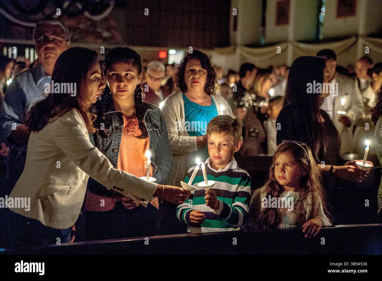 19 giugno 2017: I membri della Congregazione accendono candele durante una messa di battesimo in una cattedrale cattolica di Orange, CA. (Immagine di credito: © Spencer Grant/ZUMA Press Wire) Foto Stock