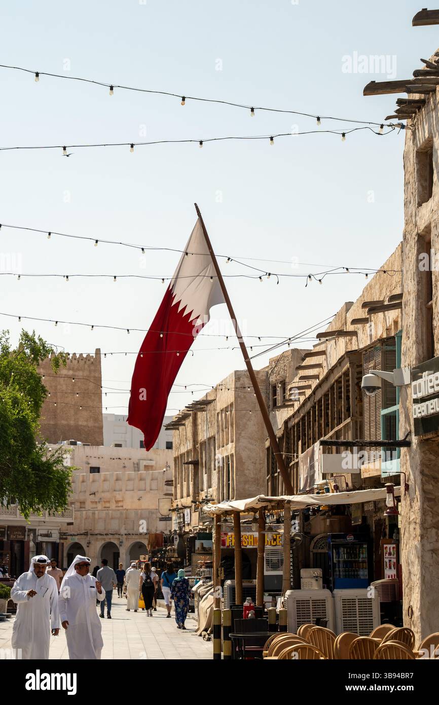 La bandiera del Qatar è orgogliosamente esposta al Souq Waqif nel centro di Doha, Qatar. Foto Stock