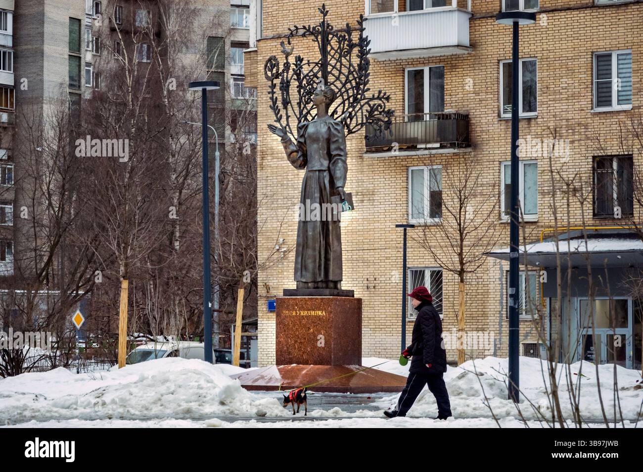 14 marzo 2023, Mosca, Mosca, Russia: Una donna fa una passeggiata con un cane sotto la statua di Lesia Ukrainka nel centro di Mosca. La statua era un simbolo della simpatia per l'Ucraina durante l'invasione russa del paese. Le persone erano solite deporre fiori nel monumento fino a quando la polizia non ha iniziato ad arrestare i sostenitori ucraini nel parco dove si trova la statua. (Immagine di credito: ¬© Celestino Arce Lavin/ZUMA Press Wire) Foto Stock