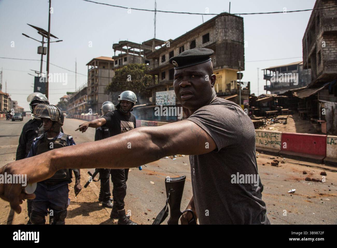 29 febbraio 2020, Conakry, Conakry, Guinea: Una brigata di polizia ordina a un gruppo di giovani manifestanti in moto che arrivano dietro di loro di fare marcia indietro prima di sparare diverse bombole di gas lacrimogeni... da metà ottobre, la capitale della Guinea vive al ritmo delle scene di guerriglia urbana tra giovani dimostranti del fronte Nazionale per la difesa della Costituzione e la polizia. Protestano contro la volontà del presidente Alpha Conde di candidarsi per un terzo mandato cambiando la Costituzione. Almeno trenta persone sono morte negli scontri dalla fine del 2019 (Credit Image: © Sadak Souici Foto Stock
