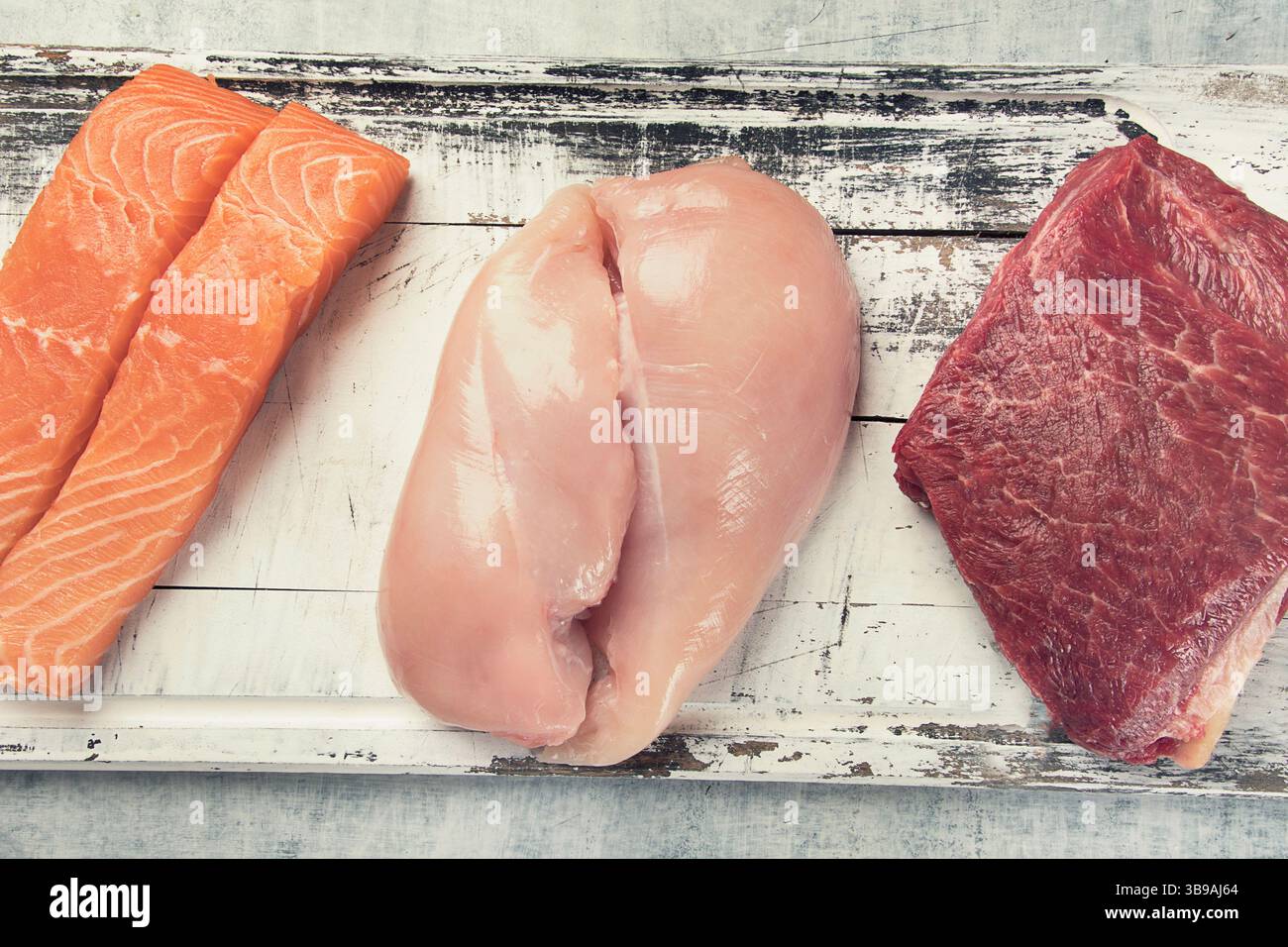 Cibo ricco di proteine: Pesce, carne su sfondo grigio. Concetto di alimentazione e dieta sana. Vista dall'alto. Foto Stock