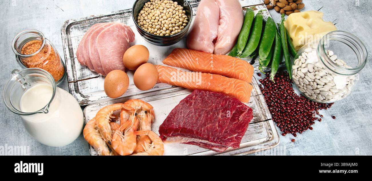 Cibo ricco di proteine: Pesce, carne, uova su sfondo grigio. Concetto di alimentazione e dieta sana. Vista dall'alto. Panorama. Foto Stock