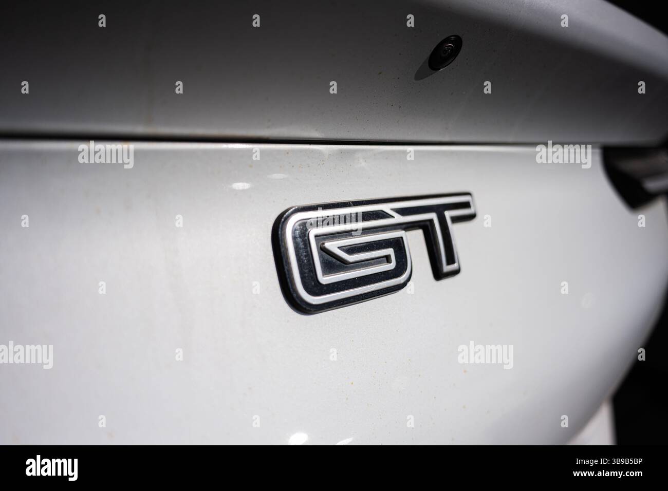 Kiev, Ucraina - 2 maggio 2025: Vista dettagliata dell'emblema Ford Mustang Mach-e GT esposto sull'esterno di un'auto bianca Foto Stock