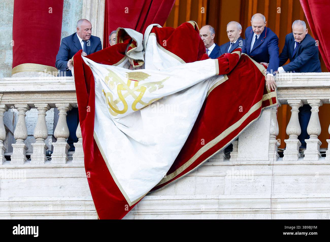 VOTO DEL PAPA VATICANO CONCLAVE personale Vaticano dispiega uno striscione con lo stemma Vaticano su un balcone della Basilica di San Pietro, prima che il nuovo papa faccia la sua prima apparizione dopo che i cardinali terminarono il conclave, in Vaticano, l'8 maggio 2025. Robert Francis Prevost è stato eletto giovedì il primo papa dagli Stati Uniti, il Vaticano ha annunciato. Moderato che era vicino a Papa Francesco e ha trascorso anni come missionario in Perù, diventa il 267° pontefice della Chiesa cattolica, assumendo il nome papale di Leone XIV.  BPH2560 Copyright: XAntonioxBalascox Foto Stock