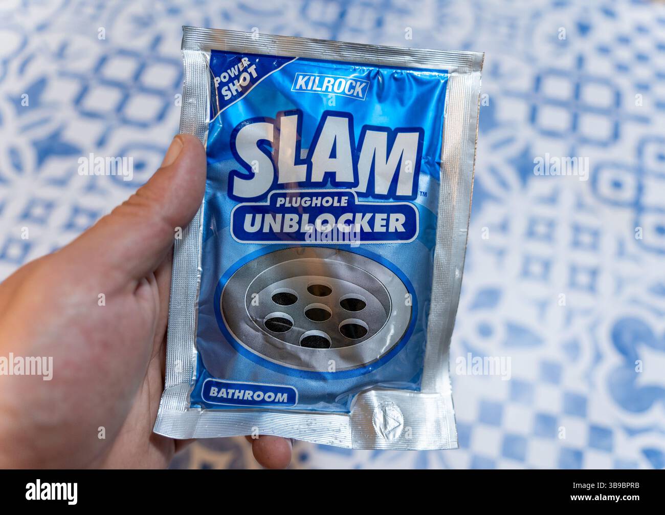 Mano che tiene in mano un pacchetto di sbloccante Plughole Kilrock Slam per gli scarichi del bagno Foto Stock
