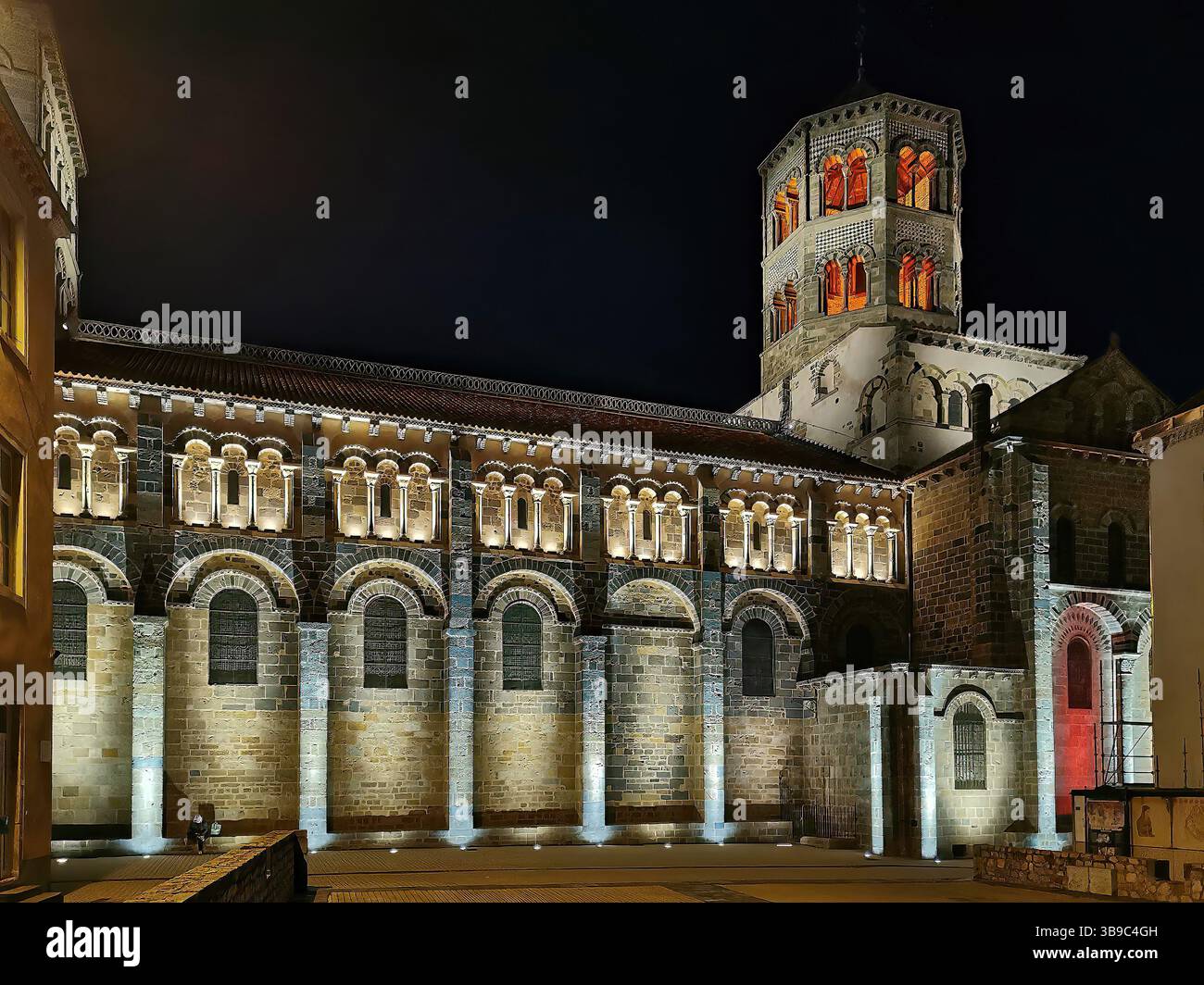 Abbatiale Saint Austremoine illuminata di notte a Issoire, con Puy de Dome in Alvernia, regione francese del Rodano Alpes - Immagine stock catturata con smartphone