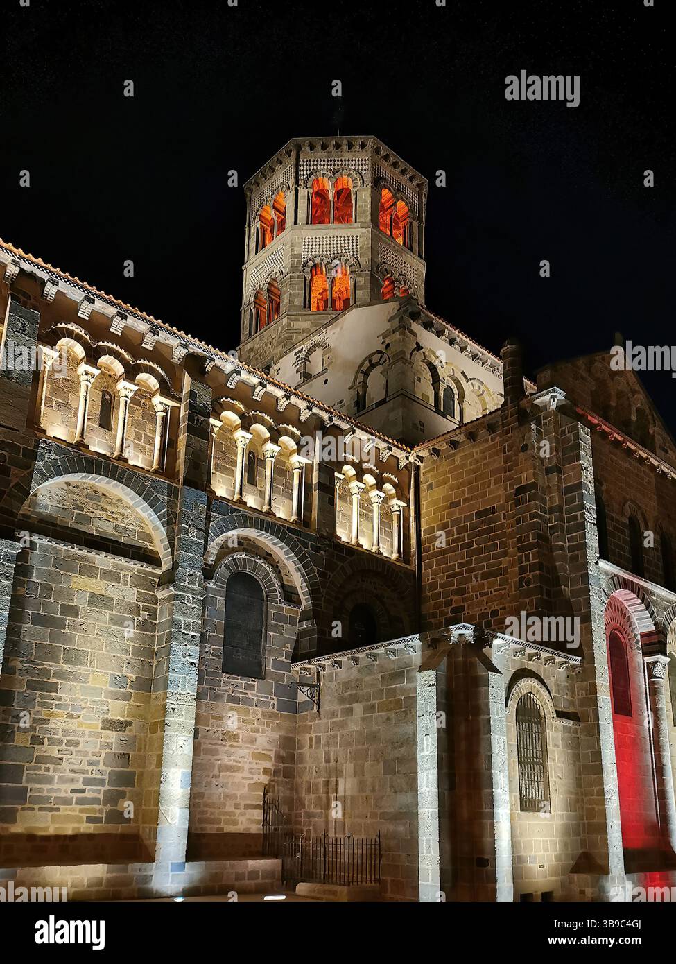 Abbatiale Saint Austremoine illuminata di notte a Issoire, con Puy de Dome in Alvernia, regione francese del Rodano Alpes - Immagine stock catturata con smartphone