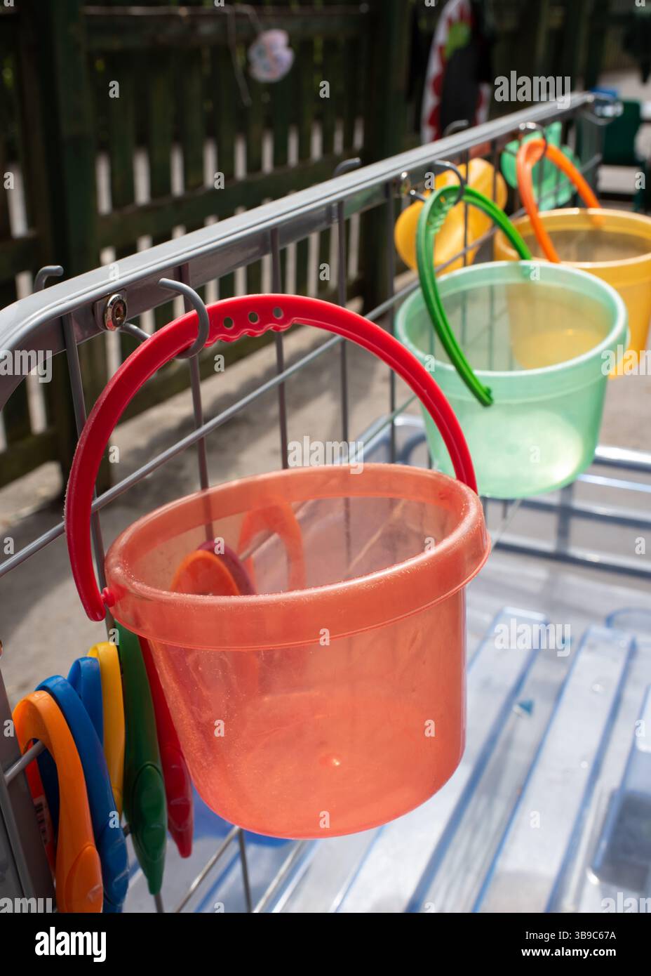 Secchi di plastica colorati appesi in un'area giochi all'aperto per l'apprendimento della scuola elementare in estate in Inghilterra, Regno Unito Foto Stock