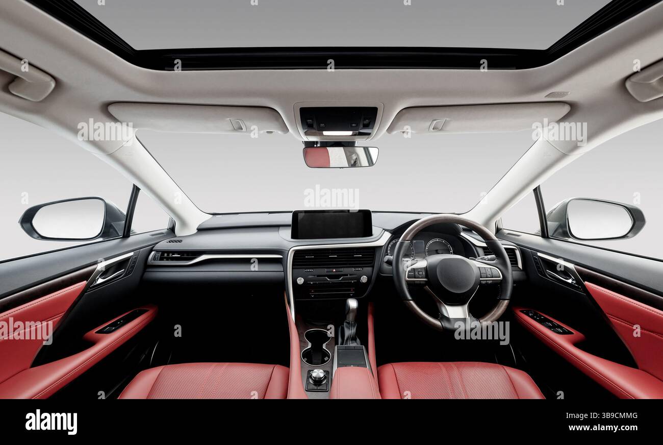 Abitacolo di lusso con guida a destra in pelle rossa. Vista del pannello anteriore della vettura: Sedili, volante, cruscotto, console centrale e tettuccio apribile. Foto Stock