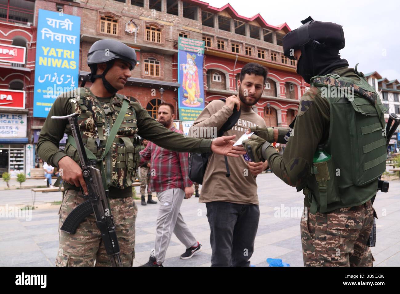 Il personale di sicurezza indiano conduce controlli approfonditi su un civile a Lal Chowk a Srinagar, in mezzo a misure di sicurezza rafforzate a seguito dell'escalation delle tensioni tra India e Pakistan. La sicurezza è stata intensificata in tutti i punti chiave della valle del Kashmir come misura precauzionale, con le forze che effettuano frisking, controlli delle borse e pattugliamento per evitare qualsiasi incidente dannoso. L'aumento della vigilanza si colloca nel contesto dei recenti scambi transfrontalieri e delle tensioni diplomatiche tra i due paesi, sollevando preoccupazioni sulla situazione della sicurezza nella regione. Kashmir. Foto Stock