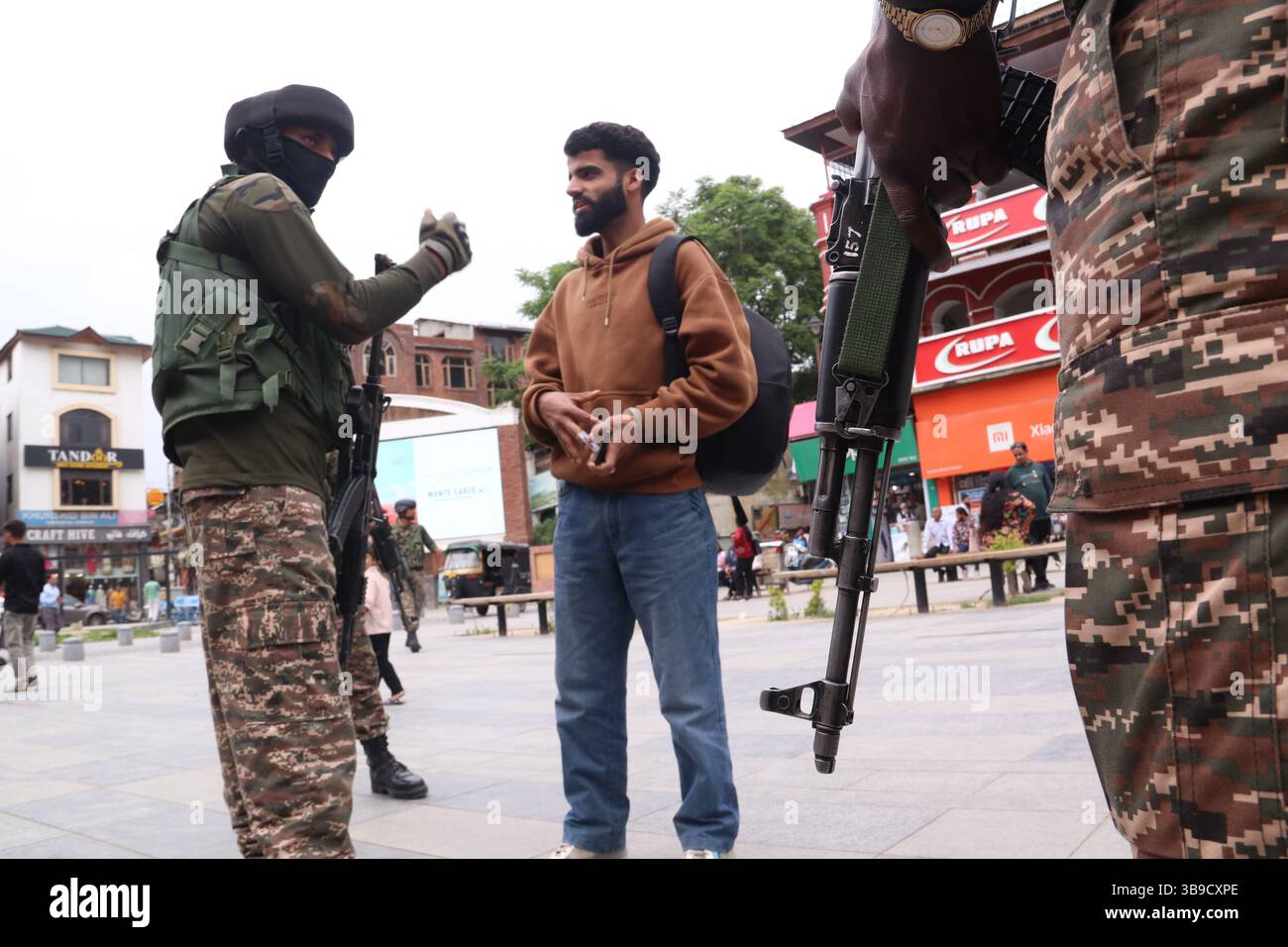Il personale di sicurezza indiano conduce controlli approfonditi su un civile a Lal Chowk a Srinagar, in mezzo a misure di sicurezza rafforzate a seguito dell'escalation delle tensioni tra India e Pakistan. La sicurezza è stata intensificata in tutti i punti chiave della valle del Kashmir come misura precauzionale, con le forze che effettuano frisking, controlli delle borse e pattugliamento per evitare qualsiasi incidente dannoso. L'aumento della vigilanza si colloca nel contesto dei recenti scambi transfrontalieri e delle tensioni diplomatiche tra i due paesi, sollevando preoccupazioni sulla situazione della sicurezza nella regione. Kashmir. Foto Stock
