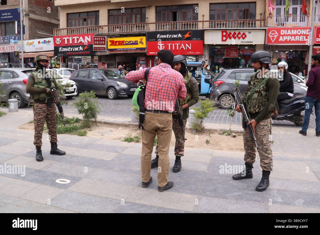 Il personale di sicurezza indiano conduce controlli approfonditi su un civile a Lal Chowk a Srinagar, in mezzo a misure di sicurezza rafforzate a seguito dell'escalation delle tensioni tra India e Pakistan. La sicurezza è stata intensificata in tutti i punti chiave della valle del Kashmir come misura precauzionale, con le forze che effettuano frisking, controlli delle borse e pattugliamento per evitare qualsiasi incidente dannoso. L'aumento della vigilanza si colloca nel contesto dei recenti scambi transfrontalieri e delle tensioni diplomatiche tra i due paesi, sollevando preoccupazioni sulla situazione della sicurezza nella regione. Kashmir. Foto Stock