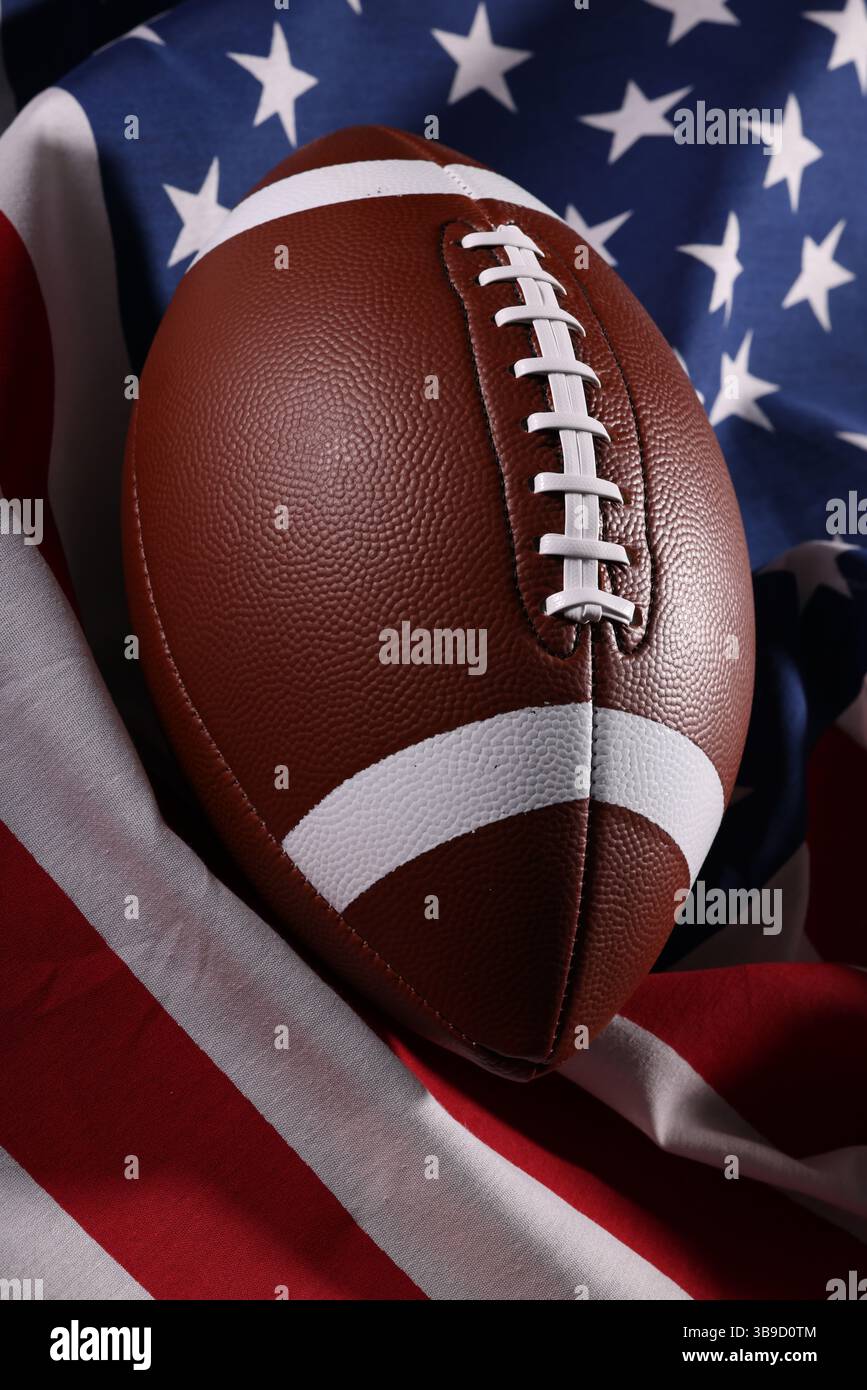 Pallone da football americano e bandiera USA. Gioco sportivo. Super Bowl negli Stati Uniti. Palla da calcio primo piano macro fotografia con spazio di copia. Foto di alta qualità Foto Stock