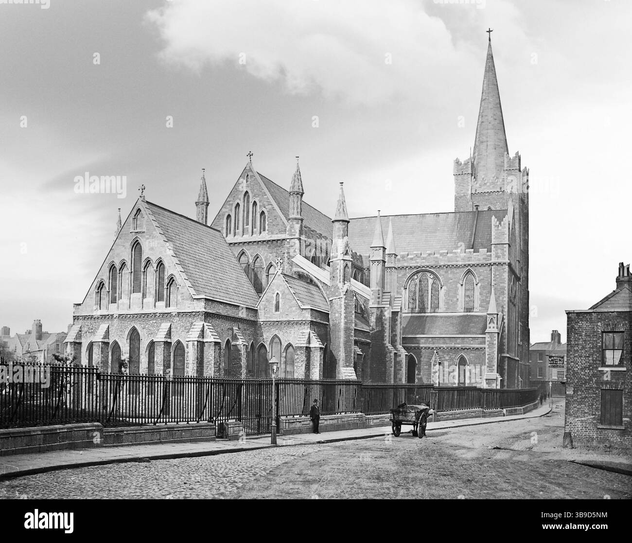 Una fotografia del tardo XIX secolo della Cattedrale di San Patrizio, la cattedrale nazionale della Chiesa d'Irlanda, da Patrick Street a Dublino, Irlanda. La base dell'attuale edificio fu costruita tra il 1191 e il 1270, anche se ora rimane poco dell'opera più antica al di là del battistero. Ispirato dalla paura, l'edificio era in pericolo imminente di crollo a metà del XIX secolo, si svolse una grande ricostruzione, pagata da Benjamin Guinness e quindi la maggior parte della cattedrale vista qui risale all'epoca vittoriana. Foto Stock