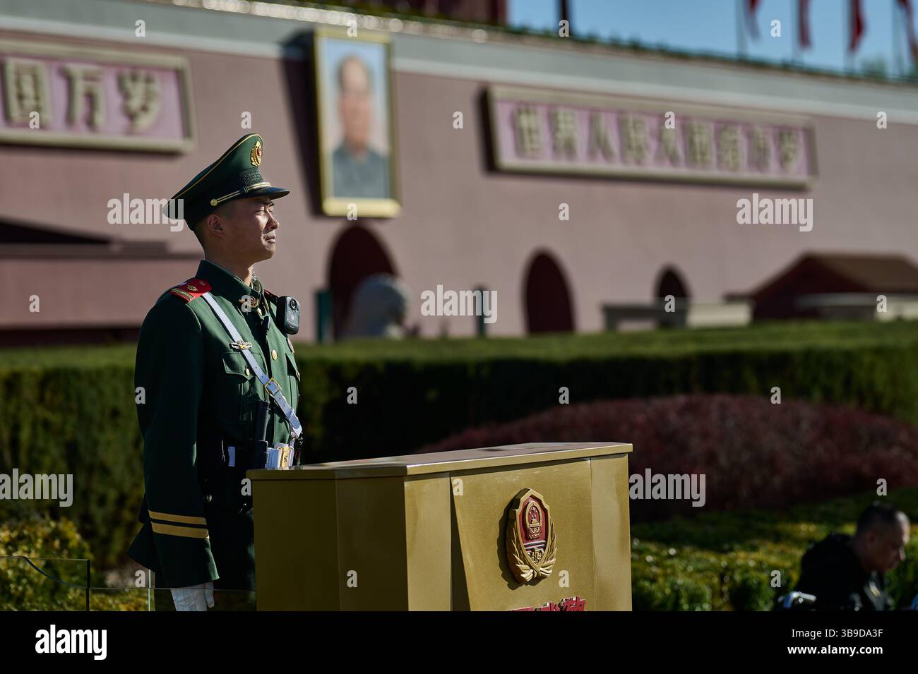 Guardia in piedi del soldato cinese alla porta di Tiananmen sotto la dura luce del giorno con architettura Monumentale sullo sfondo Foto Stock