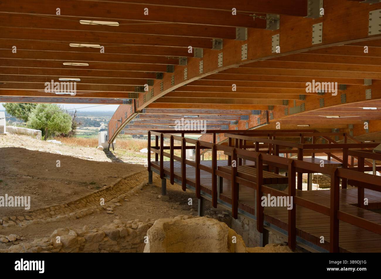 Paesaggio archeologico caratterizzato da passerelle in legno sotto un grande baldacchino moderno con vedute panoramiche della campagna, che mescolano ingegno umano e storia Foto Stock