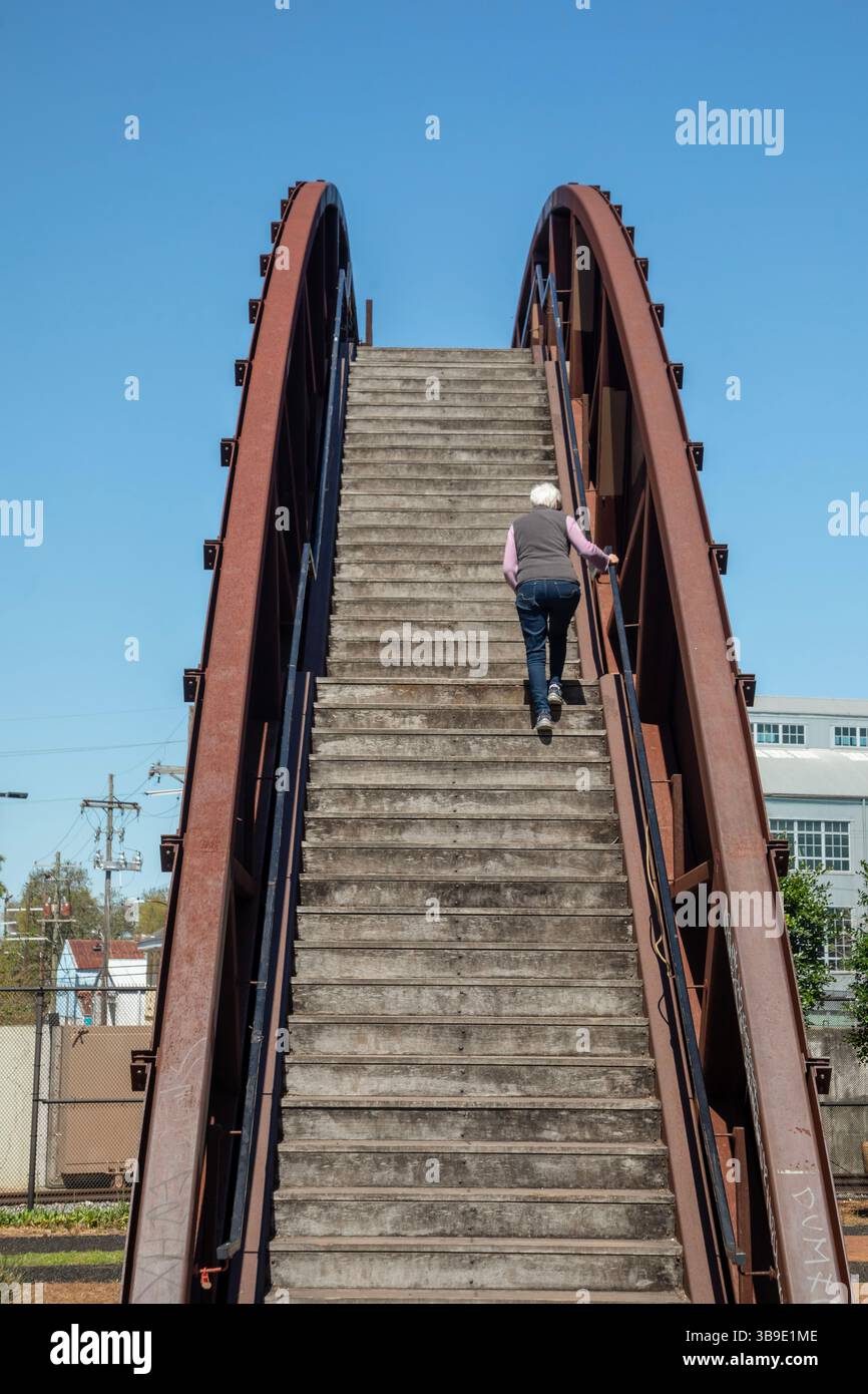 New Orleans, Louisiana - Una donna si arrampica sul Rusty Rainbow Bridge che collega il quartiere di Bywater a Crescent Park lungo il Mississippi R. Foto Stock