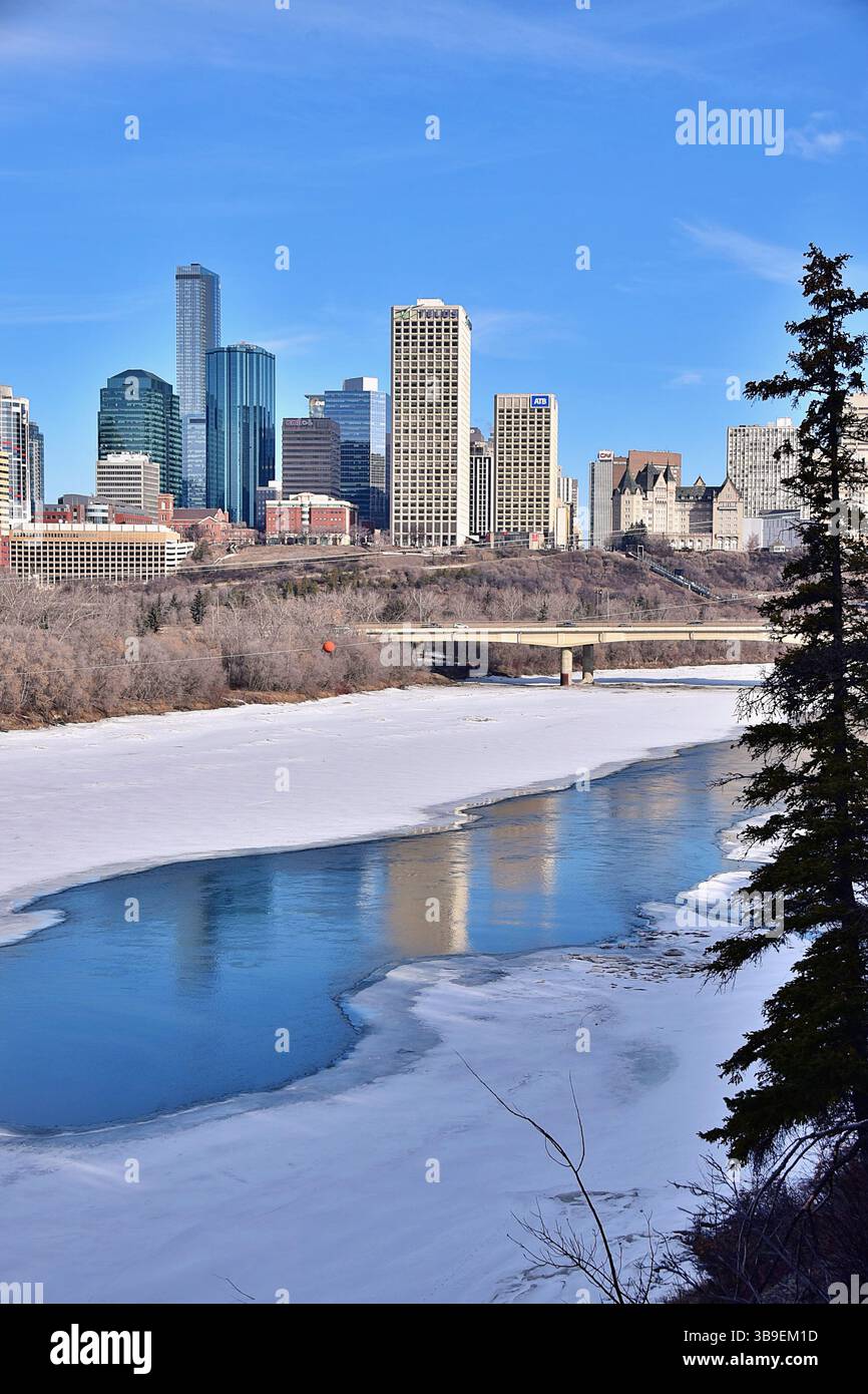 Edifici del centro di Edmonton, riflessi nel fiume North Saskatchewan, all'inizio della primavera Foto Stock