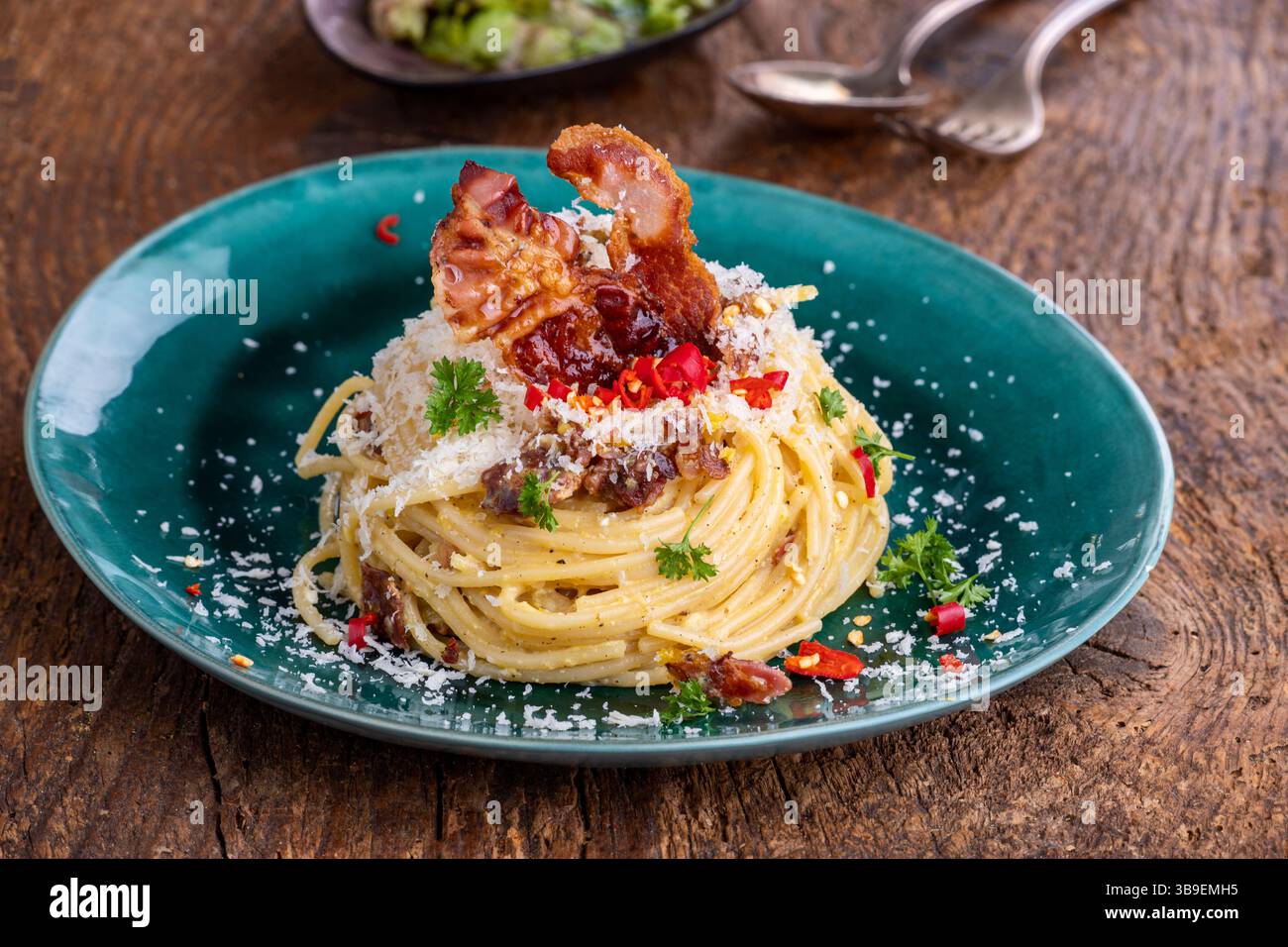 Spaghetti alla carbonara con insalata su legno Foto Stock