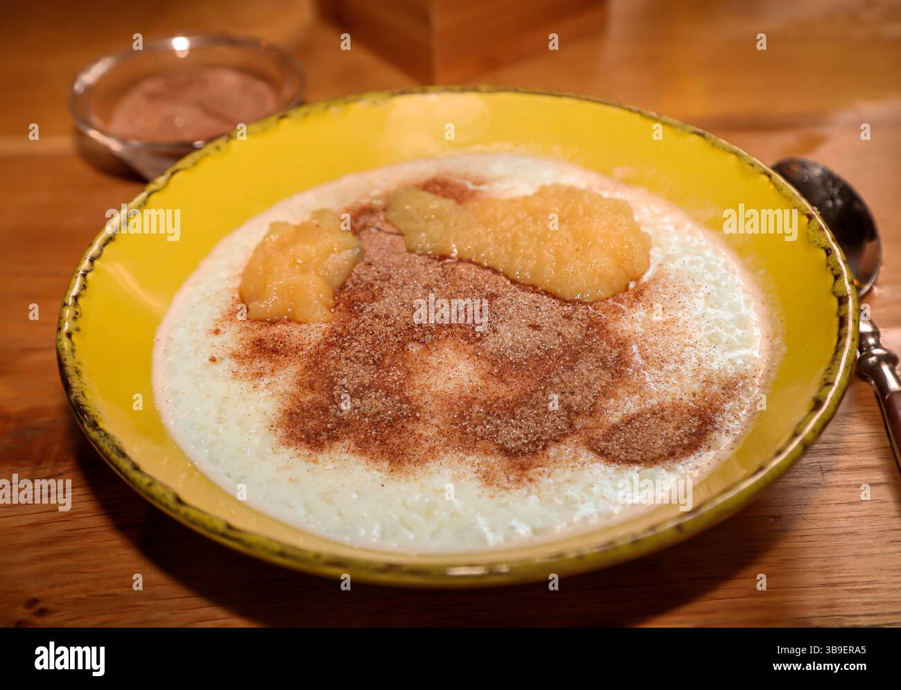 Un piatto con budino di riso, cannella e zucchero e salsa di mele Foto Stock