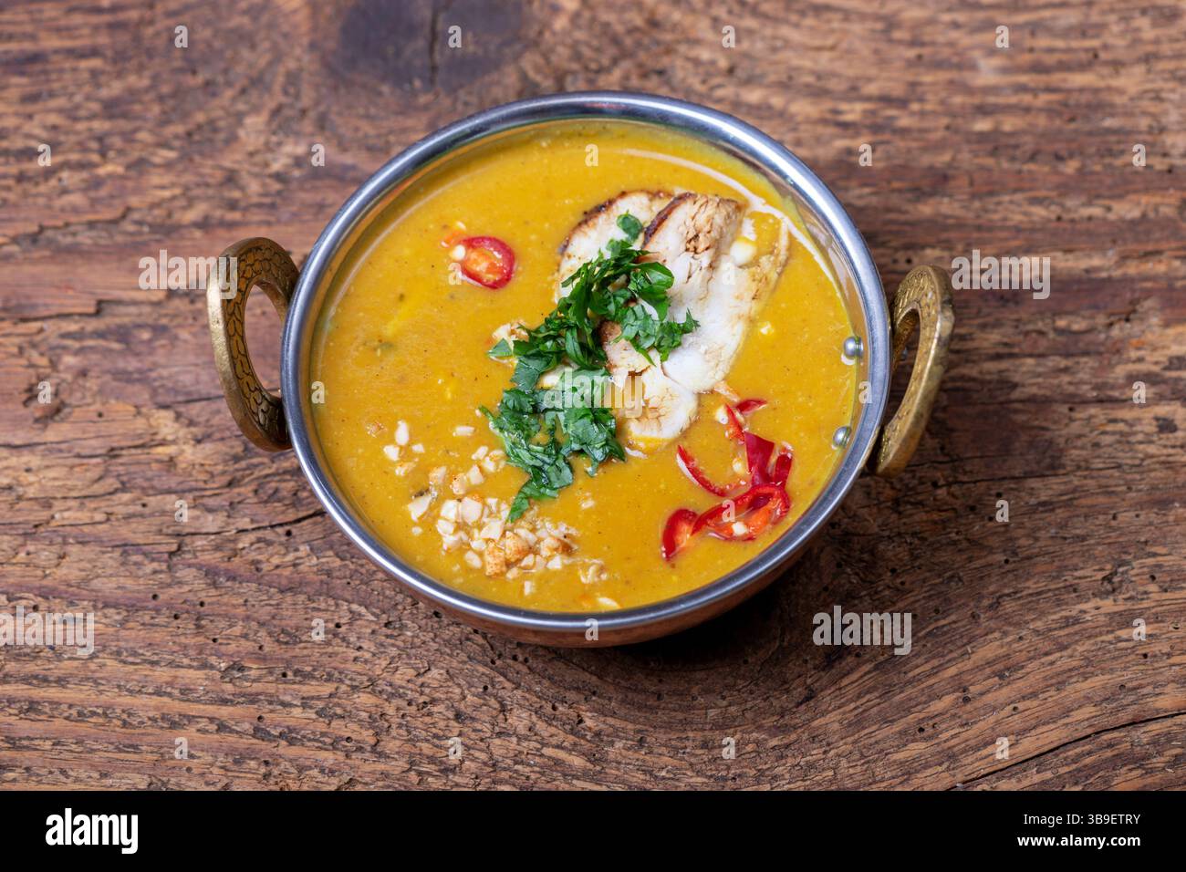 Zuppa di mulligatawny indiana in una ciotola di ottone Foto Stock