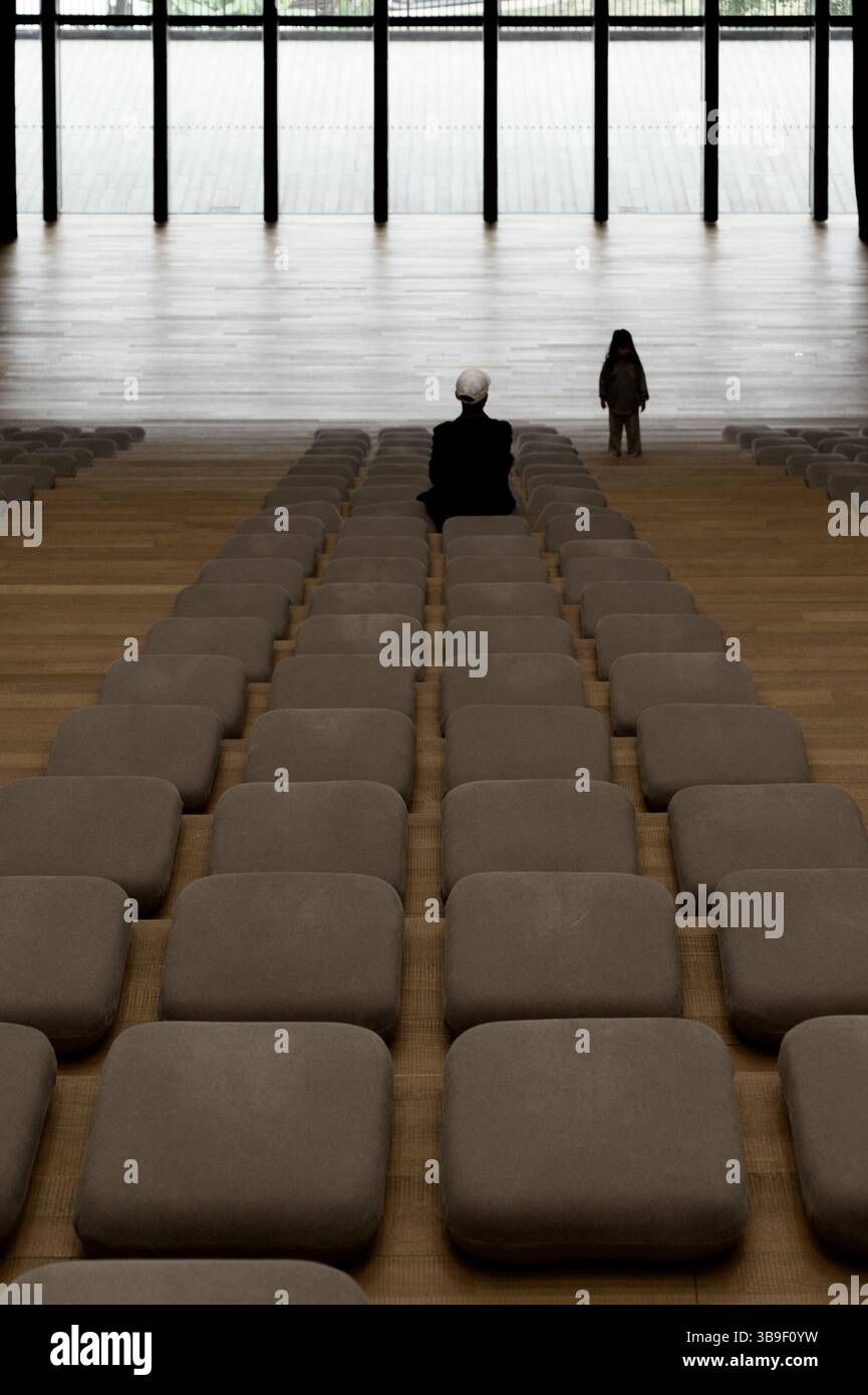 All'interno dell'auditorium M+ Museum, un momento di quiete con un solo visitatore e un bambino Foto Stock